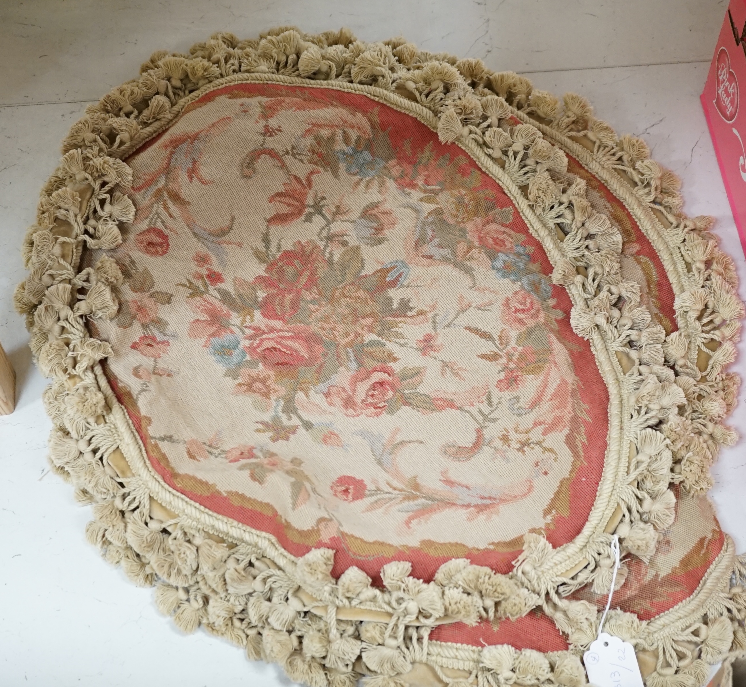 Four 20th century oval floral needleworked cushion covers with tasselled edging, 57cm wide